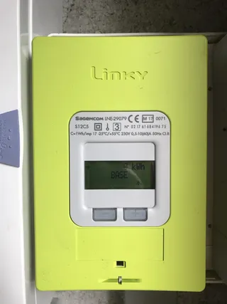 Compteur électrique Linky vert installé sur un mur, écran affichant la consommation