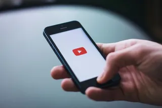Smartphone affichant le logo YouTube tenu dans une main