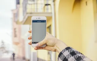 Application Instagram ouverte sur un smartphone tenu à la main