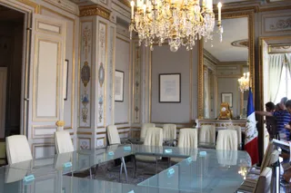 Salle des délibérés du Conseil constitutionnel français, grande table de verre et drapeau tricolore